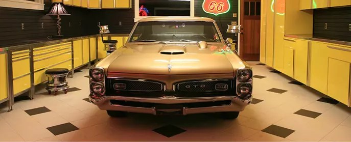 A car sitting in a retro influenced garage space.